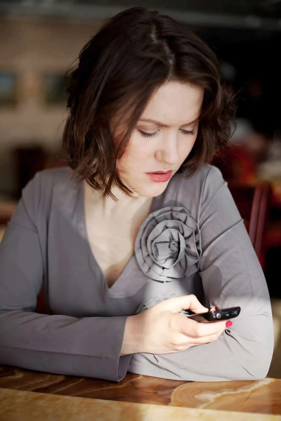 Girl with a phone on Facebook looking unhappy